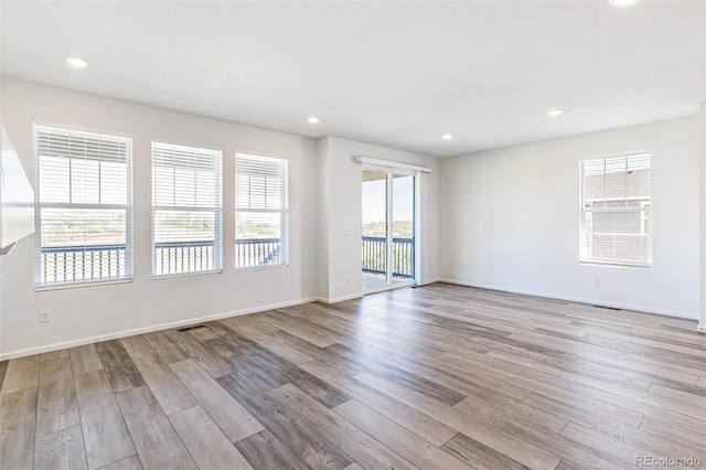 spare room with visible vents, recessed lighting, baseboards, and wood finished floors