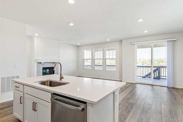 kitchen featuring a healthy amount of sunlight, visible vents, a sink, dishwasher, and open floor plan