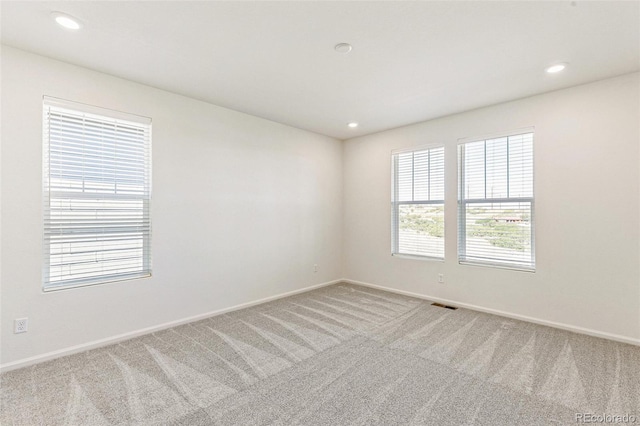 carpeted empty room with recessed lighting, visible vents, and baseboards