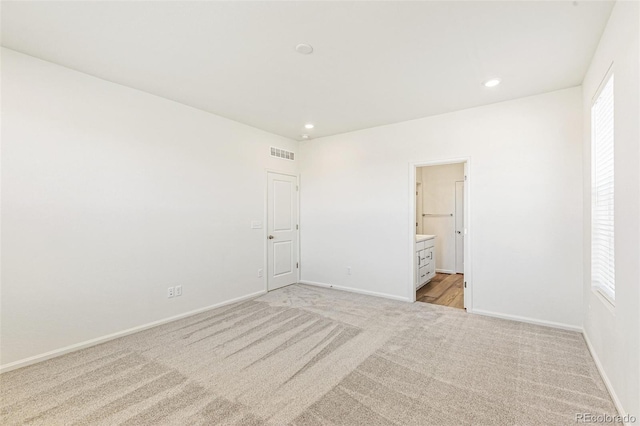 empty room featuring recessed lighting, light colored carpet, visible vents, and baseboards