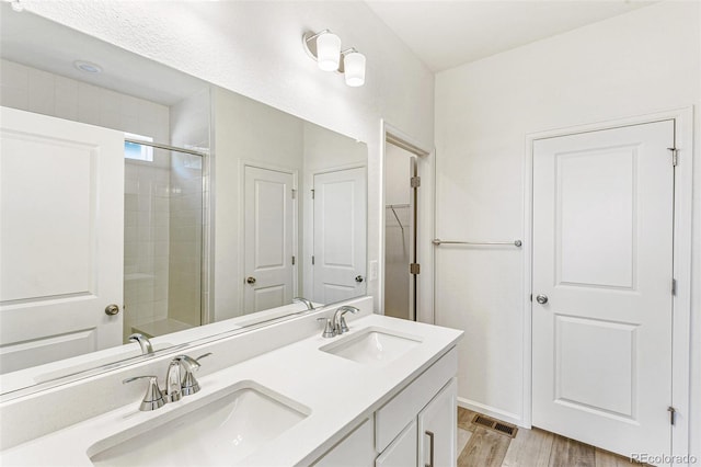 full bathroom with a closet, visible vents, double vanity, and a sink