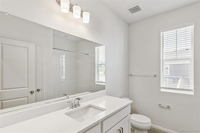 full bathroom featuring visible vents, baseboards, walk in shower, toilet, and vanity