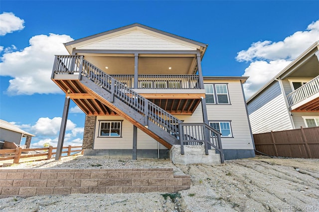 back of house featuring stairs and fence