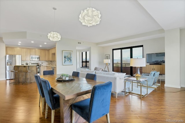 dining space with dark hardwood / wood-style flooring and an inviting chandelier