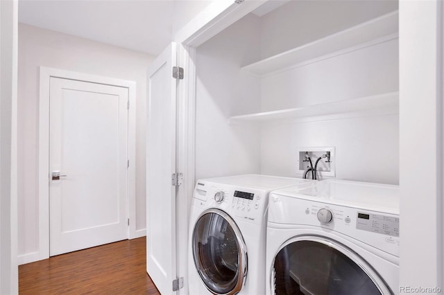 clothes washing area featuring dark wood-type flooring and washer and clothes dryer