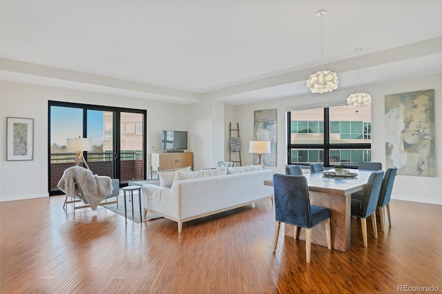 dining space with hardwood / wood-style flooring, a notable chandelier, and a healthy amount of sunlight