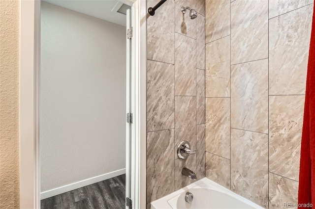 full bathroom with bathing tub / shower combination, baseboards, and wood finished floors