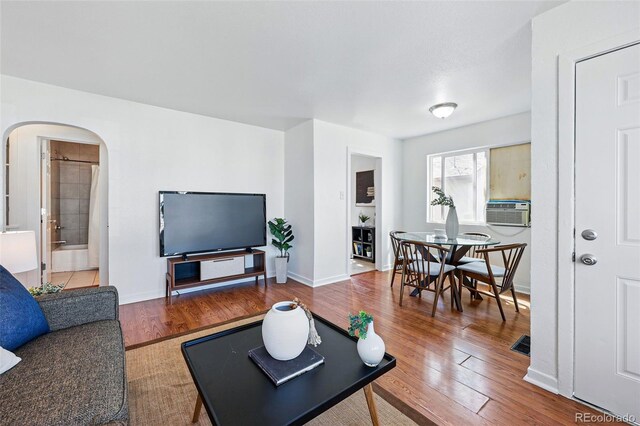 4740 Milwaukee St, Denver, CO 80216 - living room featuring arched walkways, wood finished floors, and baseboards