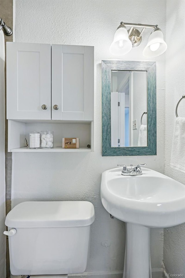 4740 Milwaukee St, Denver, CO 80216 - half bathroom with toilet, a sink, and a textured wall