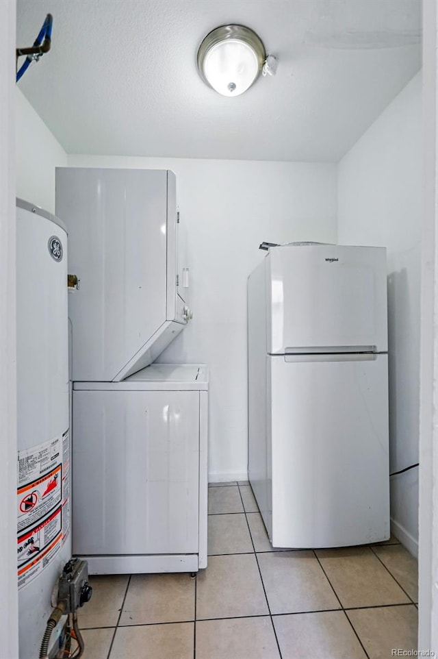 4740 Milwaukee St, Denver, CO 80216 - clothes washing area with stacked washer and clothes dryer, gas water heater, and light tile patterned flooring