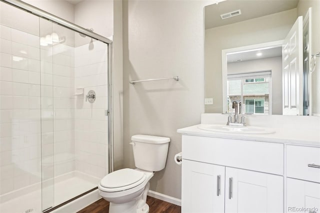 full bath with toilet, wood finished floors, a shower stall, vanity, and baseboards