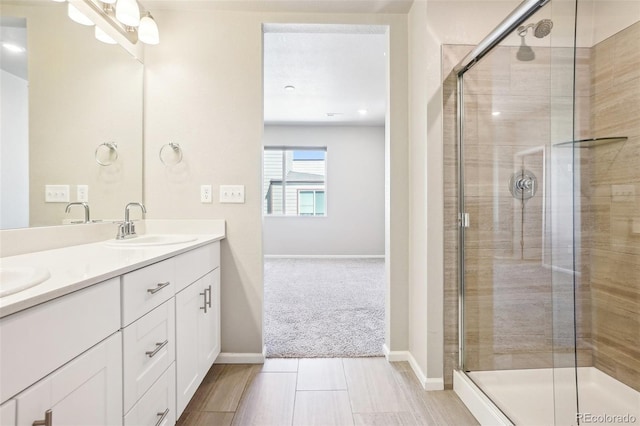 full bath with a shower stall, double vanity, and baseboards