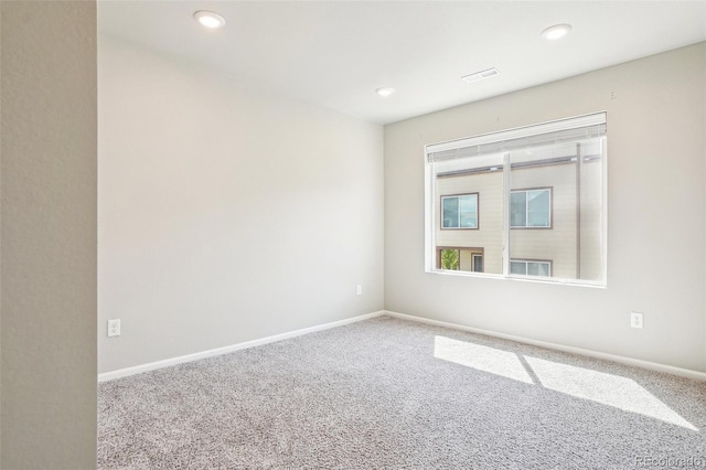 carpeted empty room featuring recessed lighting and baseboards