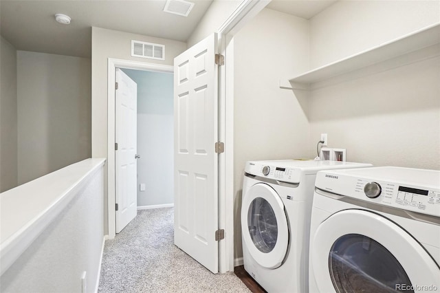 laundry room with washing machine and clothes dryer, light carpet, and baseboards