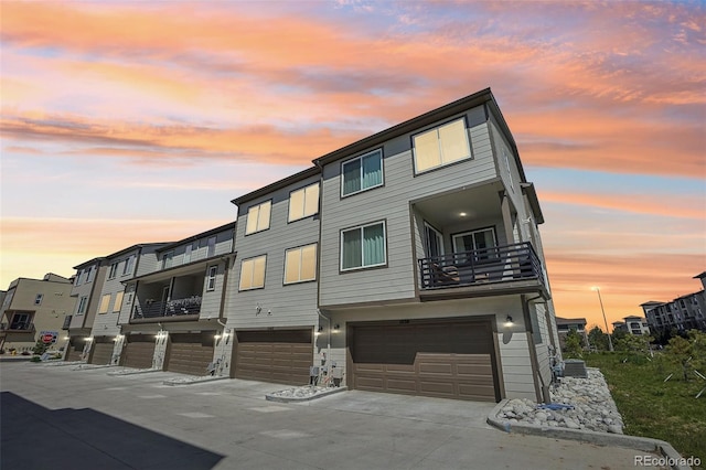 view of front of house with a balcony, a garage, and driveway