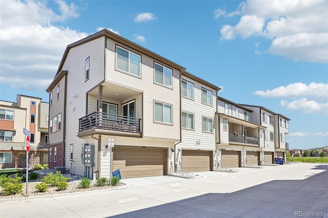 view of property with an attached garage, driveway, and a residential view