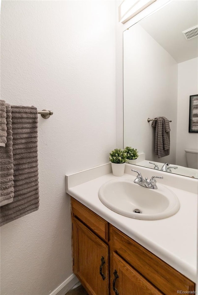 bathroom featuring vanity and toilet