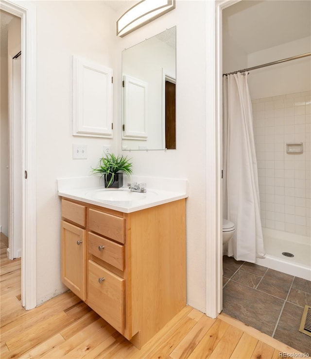 bathroom featuring walk in shower, vanity, toilet, and hardwood / wood-style flooring