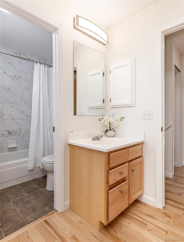 full bathroom with vanity, toilet, shower / tub combo, and a textured ceiling