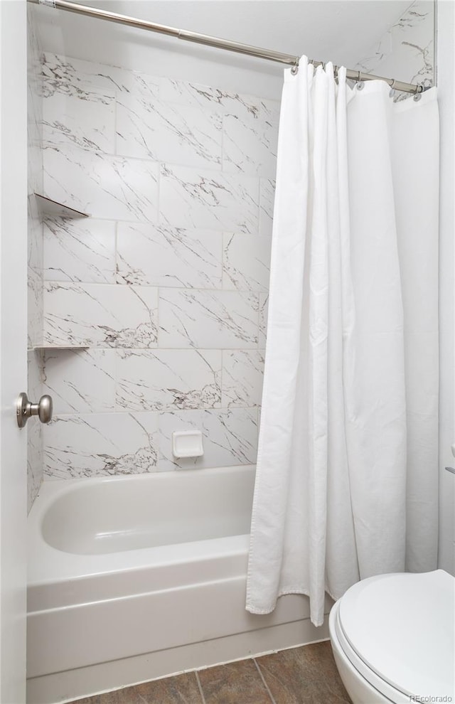 bathroom with shower / tub combo and toilet