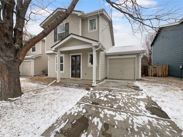 view of front of home featuring an attached garage, covered porch, and fence