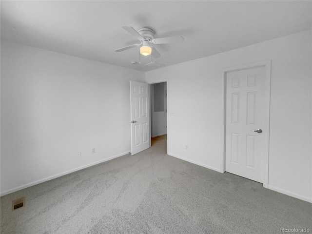 unfurnished bedroom with a ceiling fan, carpet flooring, visible vents, and baseboards