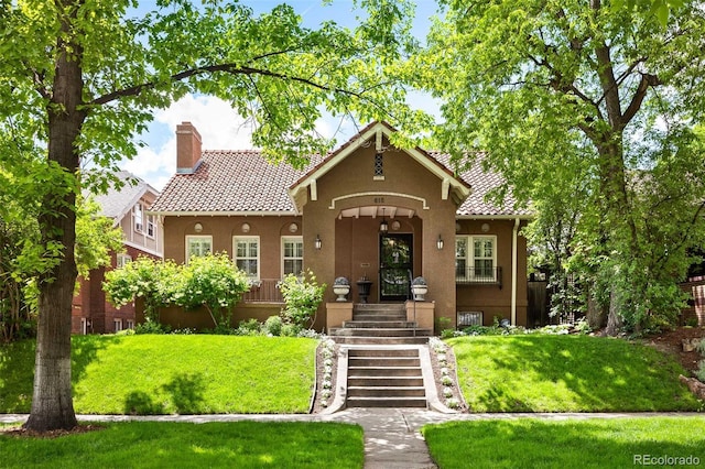 615 N Williams St, Denver, CO 80218 - view of front of home featuring stucco siding, a chimney, a front yard, and a tile roof