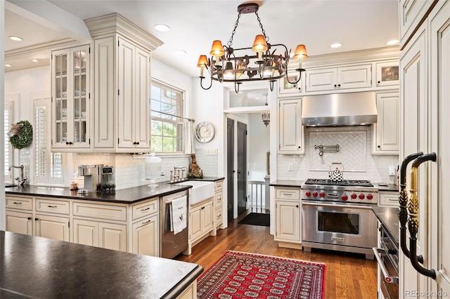 615 N Williams St, Denver, CO 80218 - kitchen with stainless steel appliances, extractor fan, dark countertops, a chandelier, and decorative backsplash