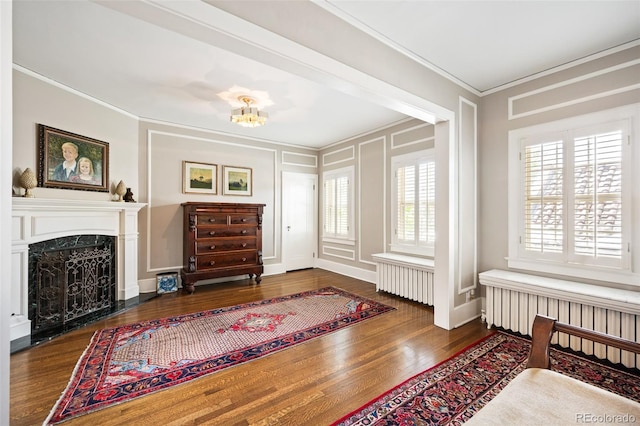 615 N Williams St, Denver, CO 80218 - living area with crown molding, wood finished floors, radiator heating unit, a fireplace, and a decorative wall