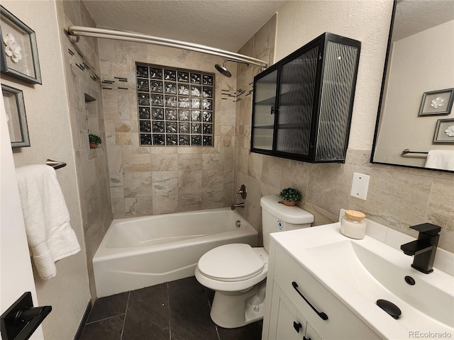 full bathroom featuring a textured ceiling, tile walls, tile patterned floors, tiled shower / bath combo, and vanity