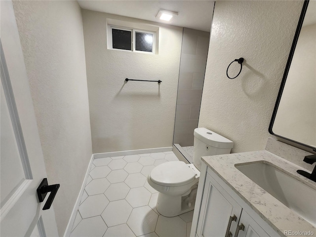 bathroom with toilet, a shower, vanity, and tile patterned floors