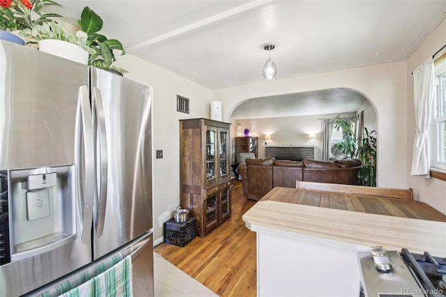 1975 Cody St, Lakewood, CO 80215 - kitchen with stainless steel refrigerator with ice dispenser, arched walkways, light wood finished floors, and hanging light fixtures