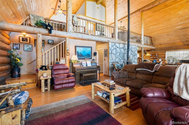 living room featuring rustic walls, wood ceiling, wood finished floors, and stairs