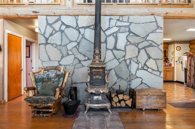 interior details featuring a wood stove, wood finished floors, and freestanding refrigerator