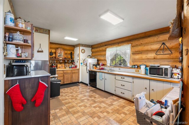 kitchen featuring light tile patterned flooring, rustic walls, white cabinets, dishwasher, and sink