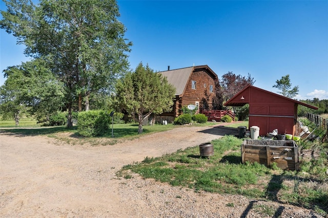 view of yard featuring an outbuilding, a barn, and dirt driveway