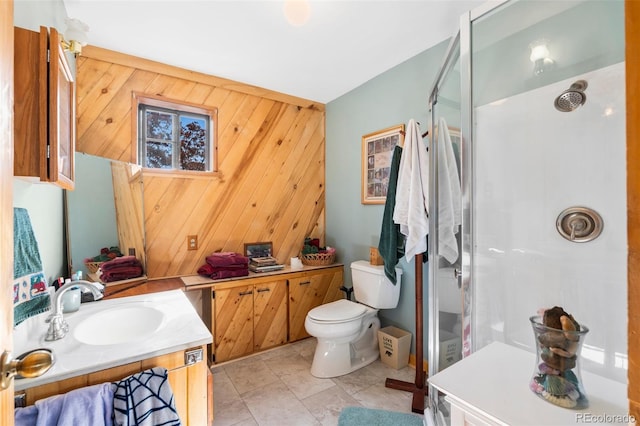 full bath featuring a shower stall, toilet, vanity, and wood walls