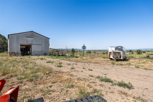 view of yard featuring a rural view and an outbuilding