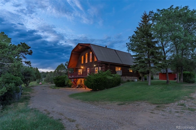 view of side of home featuring a yard, a gambrel roof, metal roof, and dirt driveway