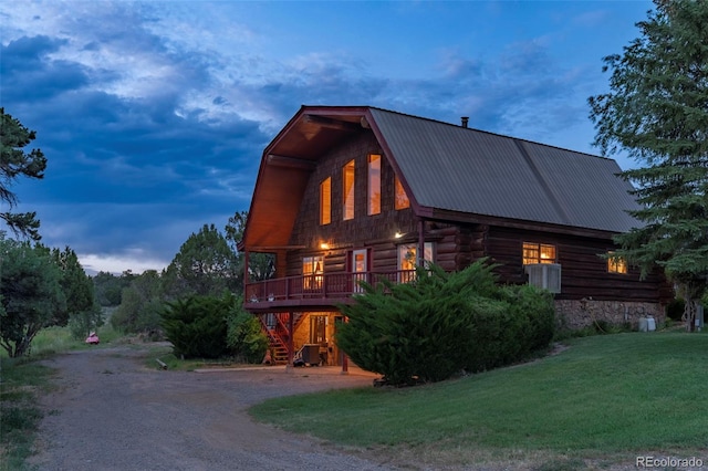 property exterior at dusk featuring a yard and central AC unit