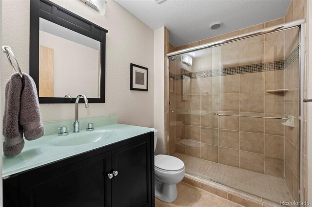 full bathroom featuring a stall shower, toilet, vanity, and tile patterned floors