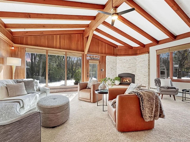 sunroom / solarium featuring ceiling fan, a baseboard radiator, a stone fireplace, and vaulted ceiling with beams