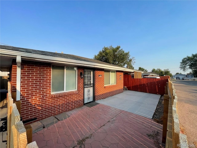 single story home featuring fence, a patio, and brick siding