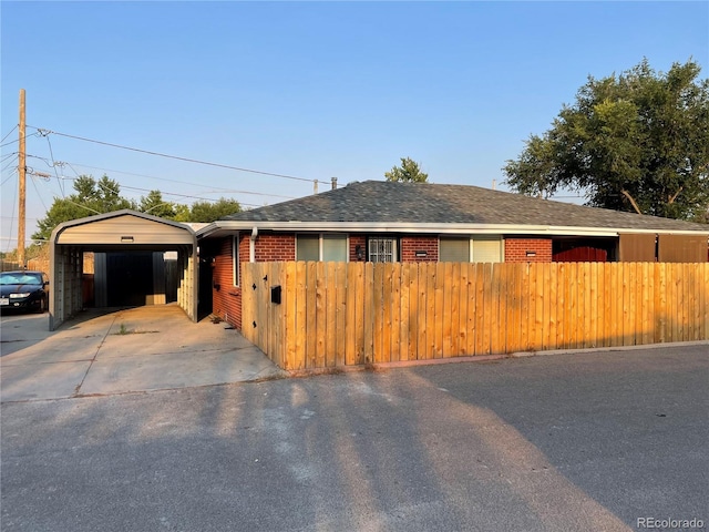view of front of property with concrete driveway, a shingled roof, a garage, and fence