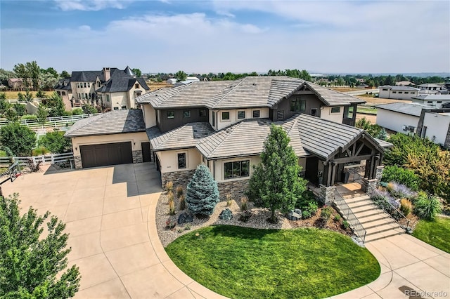 view of front of home with stucco siding, stone siding, fence, concrete driveway, and a garage