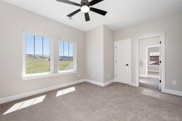 unfurnished room featuring plenty of natural light, ceiling fan, and light carpet