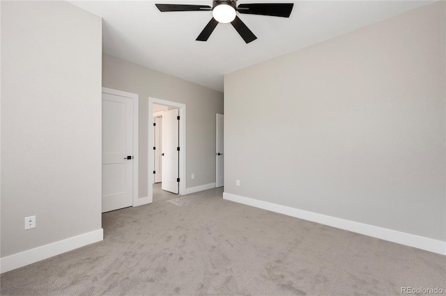 empty room with ceiling fan and light carpet