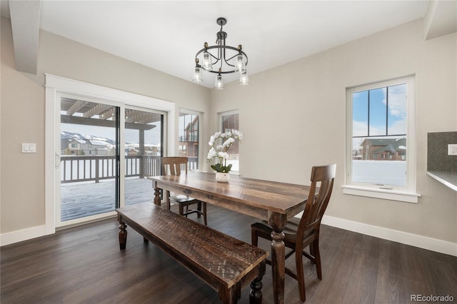 dining space with a notable chandelier, a healthy amount of sunlight, and dark hardwood / wood-style flooring