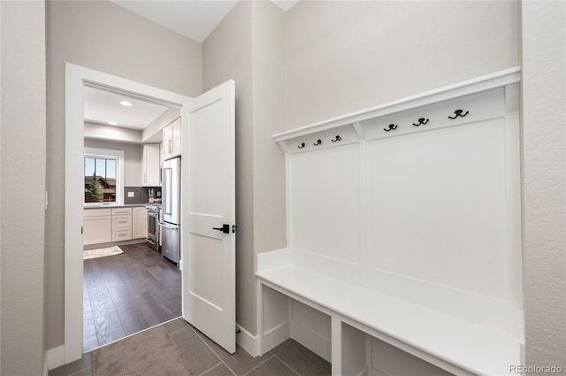 mudroom with dark tile patterned floors