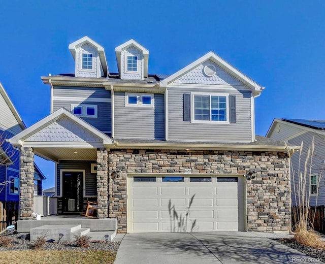 view of front facade featuring stone siding, covered porch, concrete driveway, and an attached garage